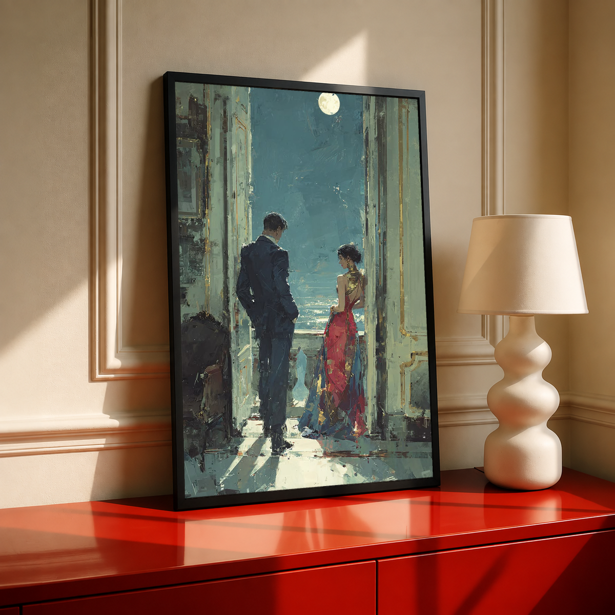 Couple on a moonlit balcony in a black frame on a red cabinet beside a cream lamp