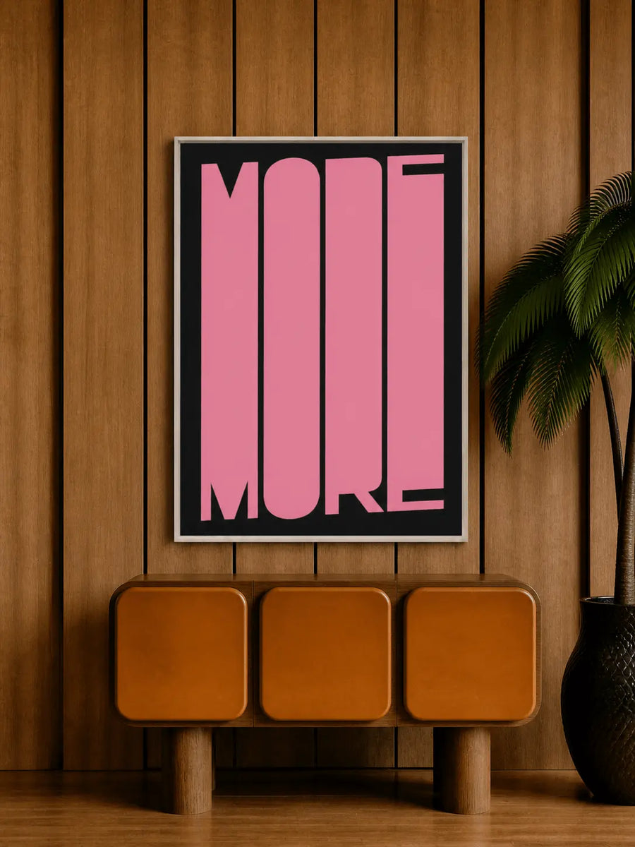 Framed typography art print with pink 'MORE' on black background, dark frame