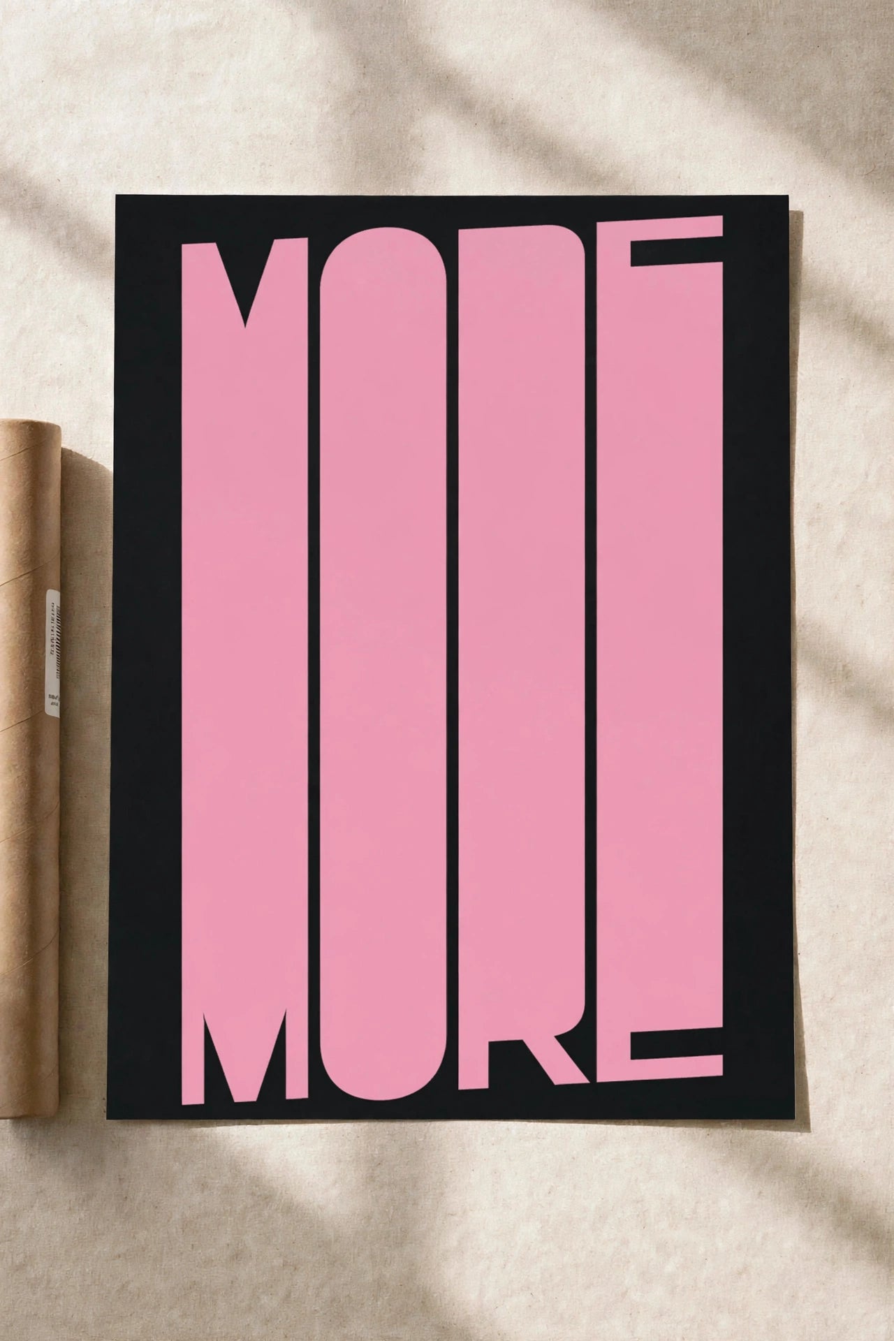 Black-framed typography print with large pink 'MORE' letters.