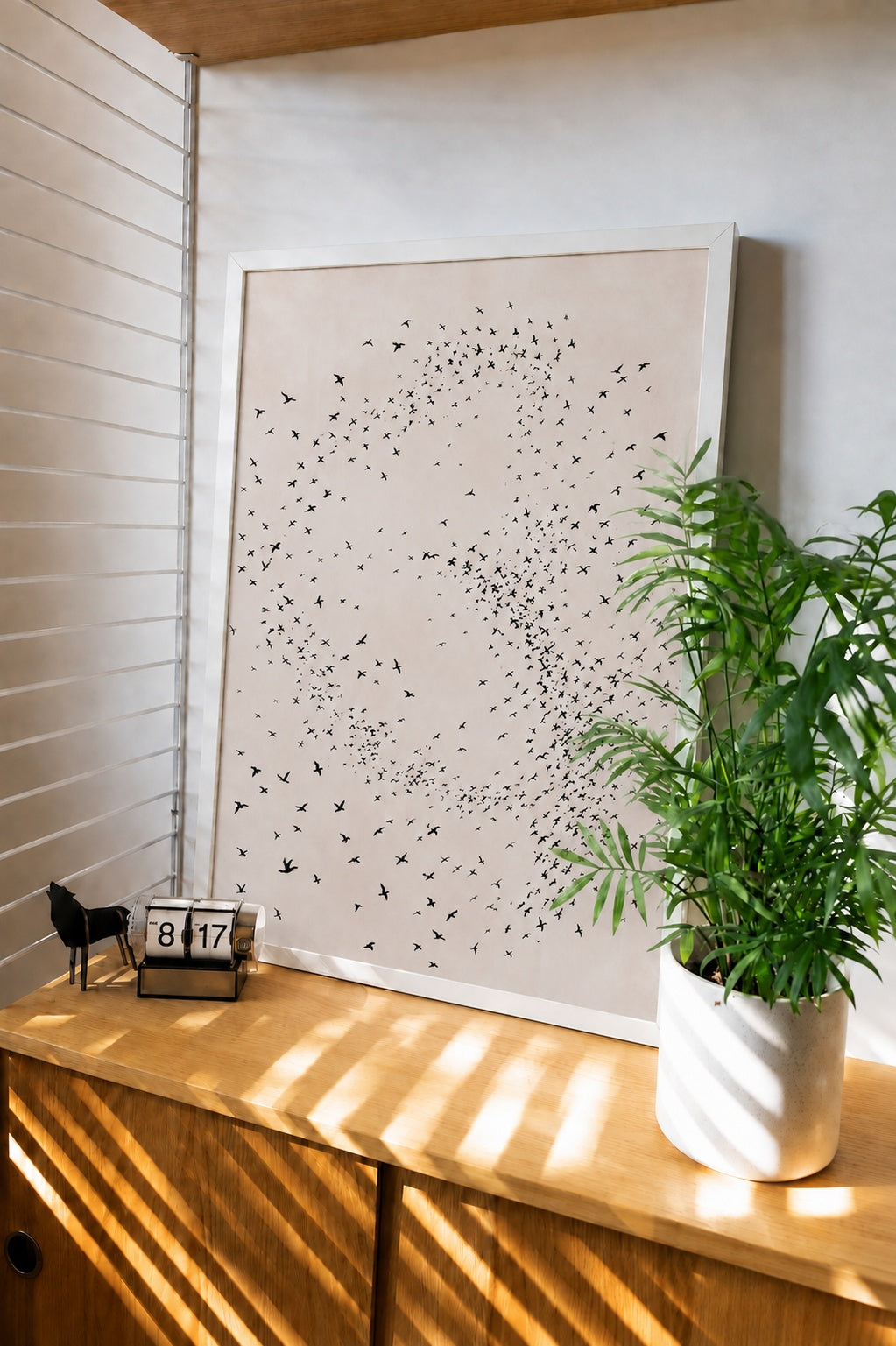 Framed minimalist bird wall art print with flock of dots forming a swirl