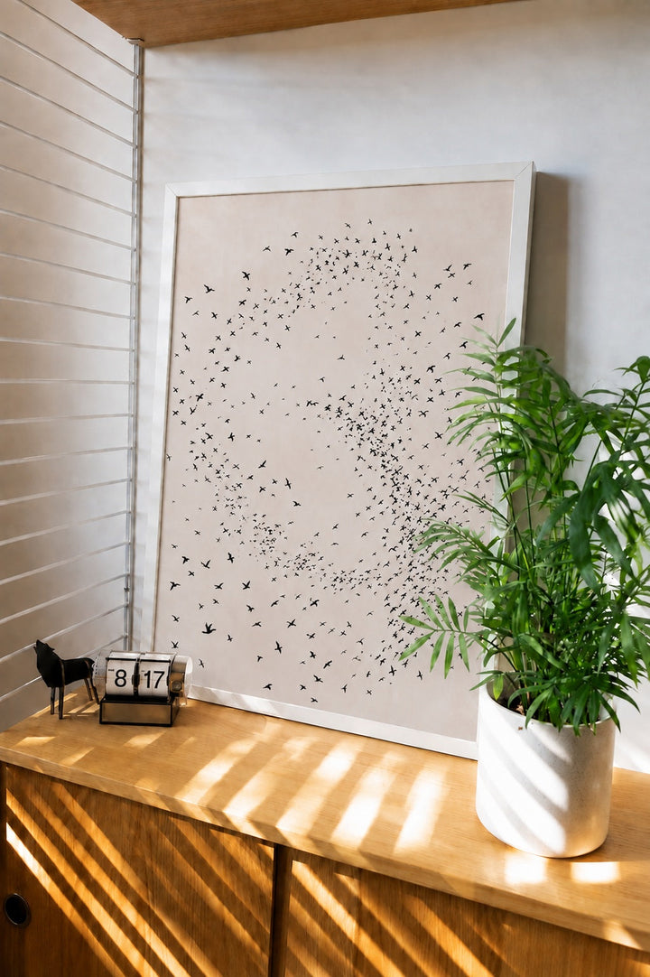 Framed minimalist bird wall art print with flock of dots forming a swirl