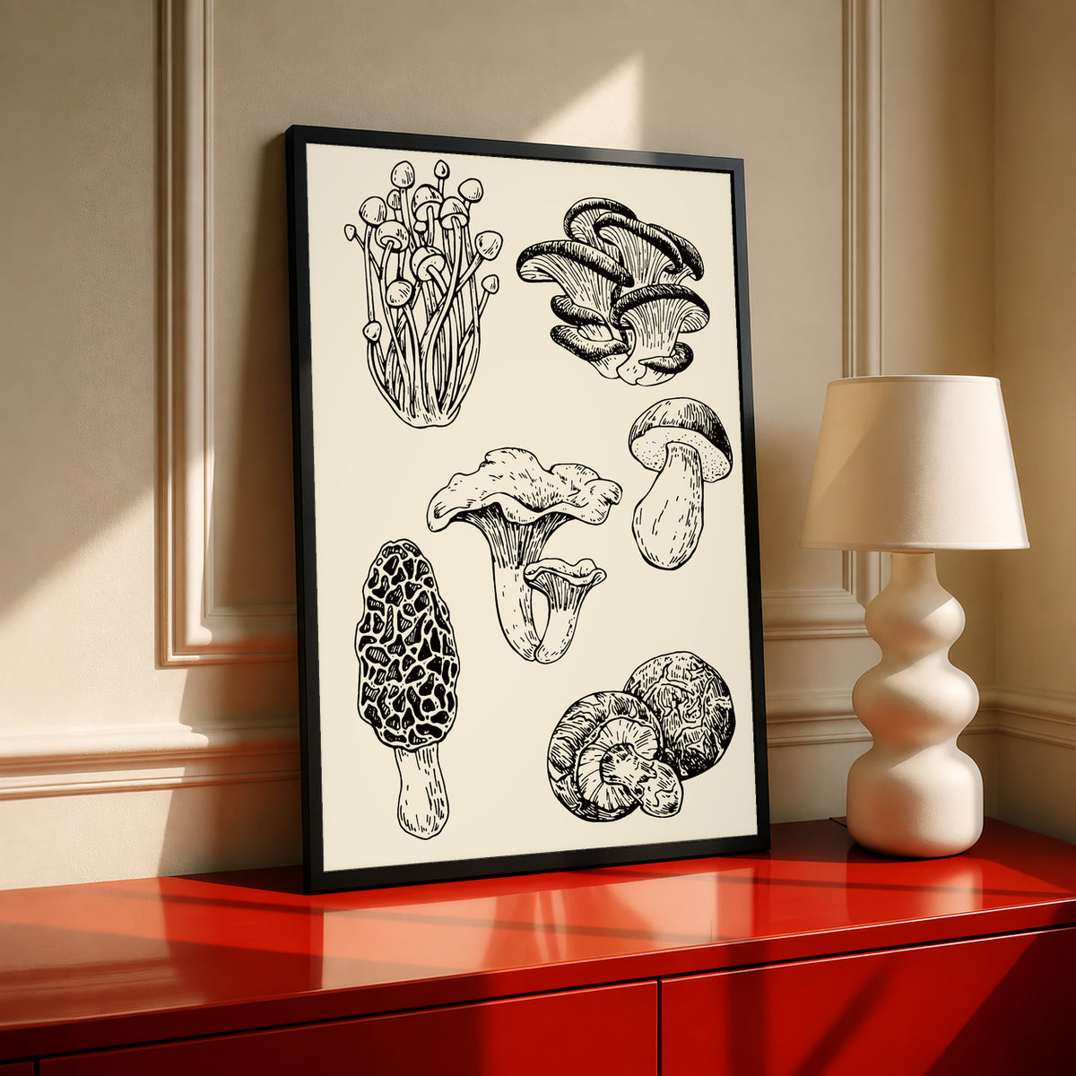Six mushroom specimen studies with varied caps stems and gills in black ink style in a black frame on a red cabinet beside a cream lamp