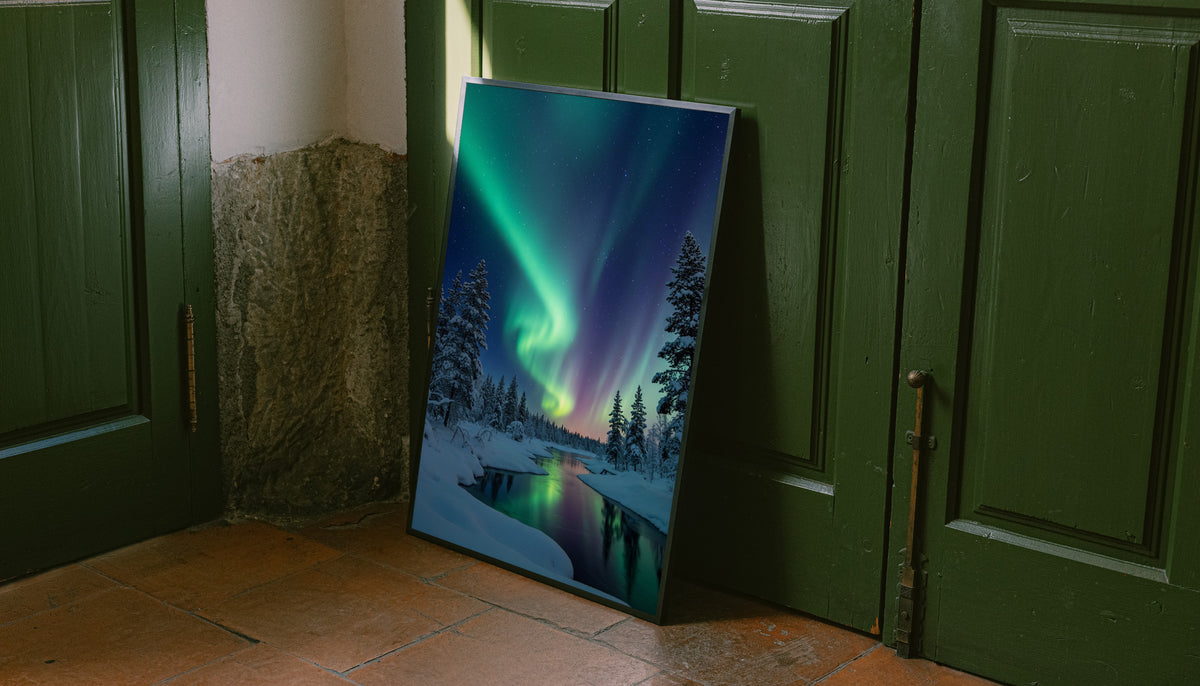 Framed landscape wall art with green aurora over snowy pine trees and dark river