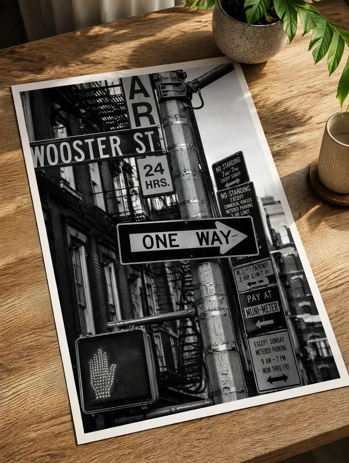 Street sign art print on tabletop, black-and-white “One Way” sign with street markers.