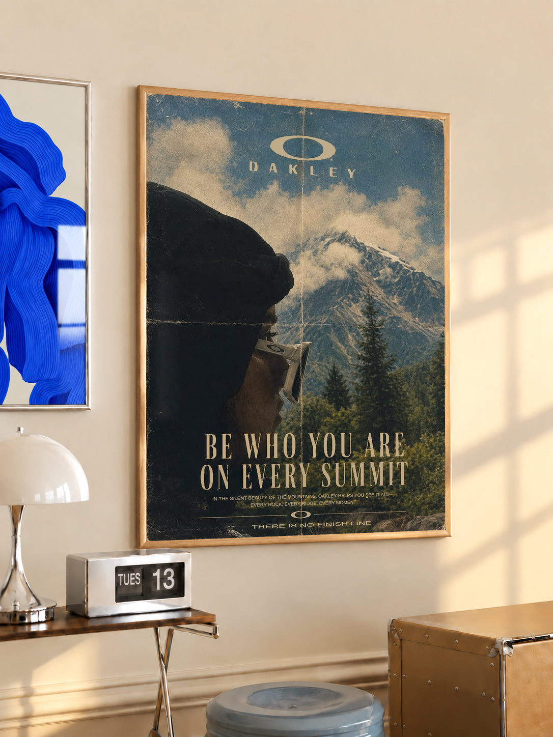 Framed blue mountain poster with Oakley logo and gold "Be who you are on every summit"
