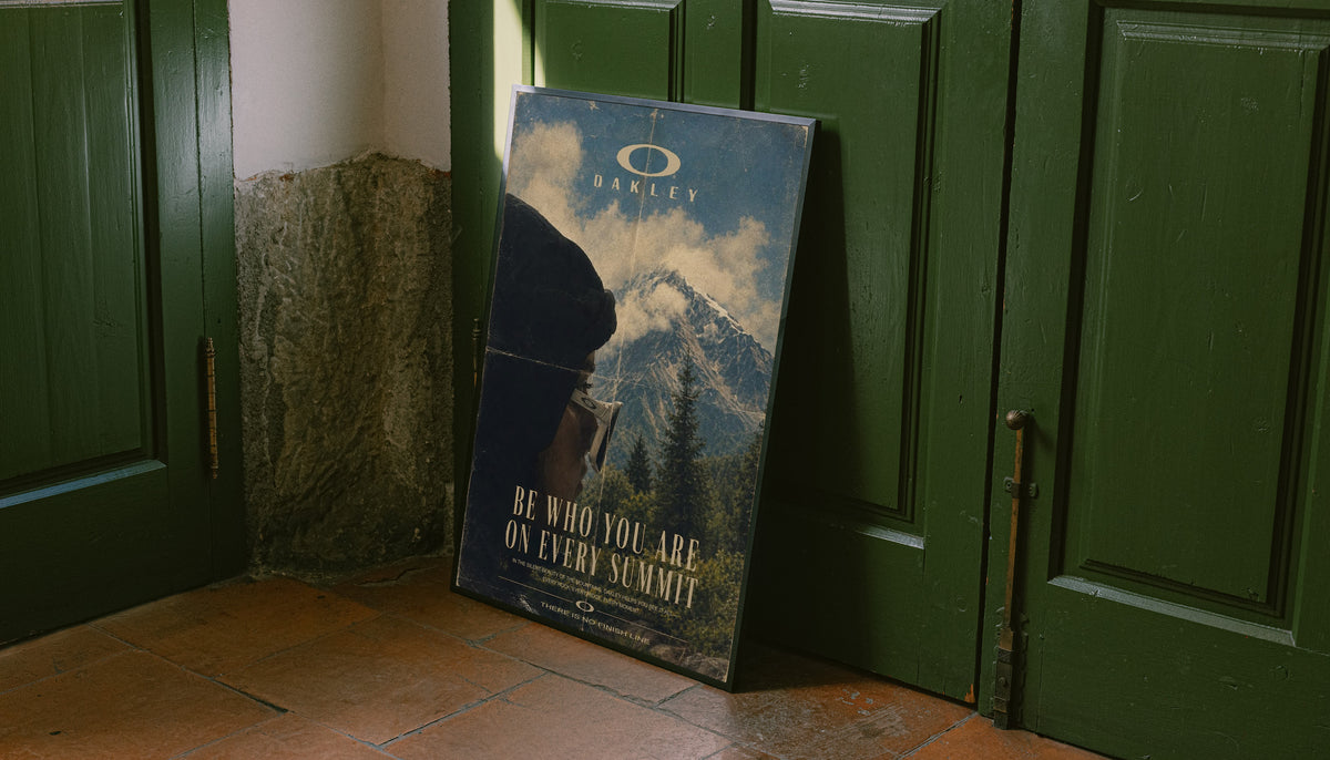 Blue mountain poster with Oakley logo and gold "Be who you are on every summit"