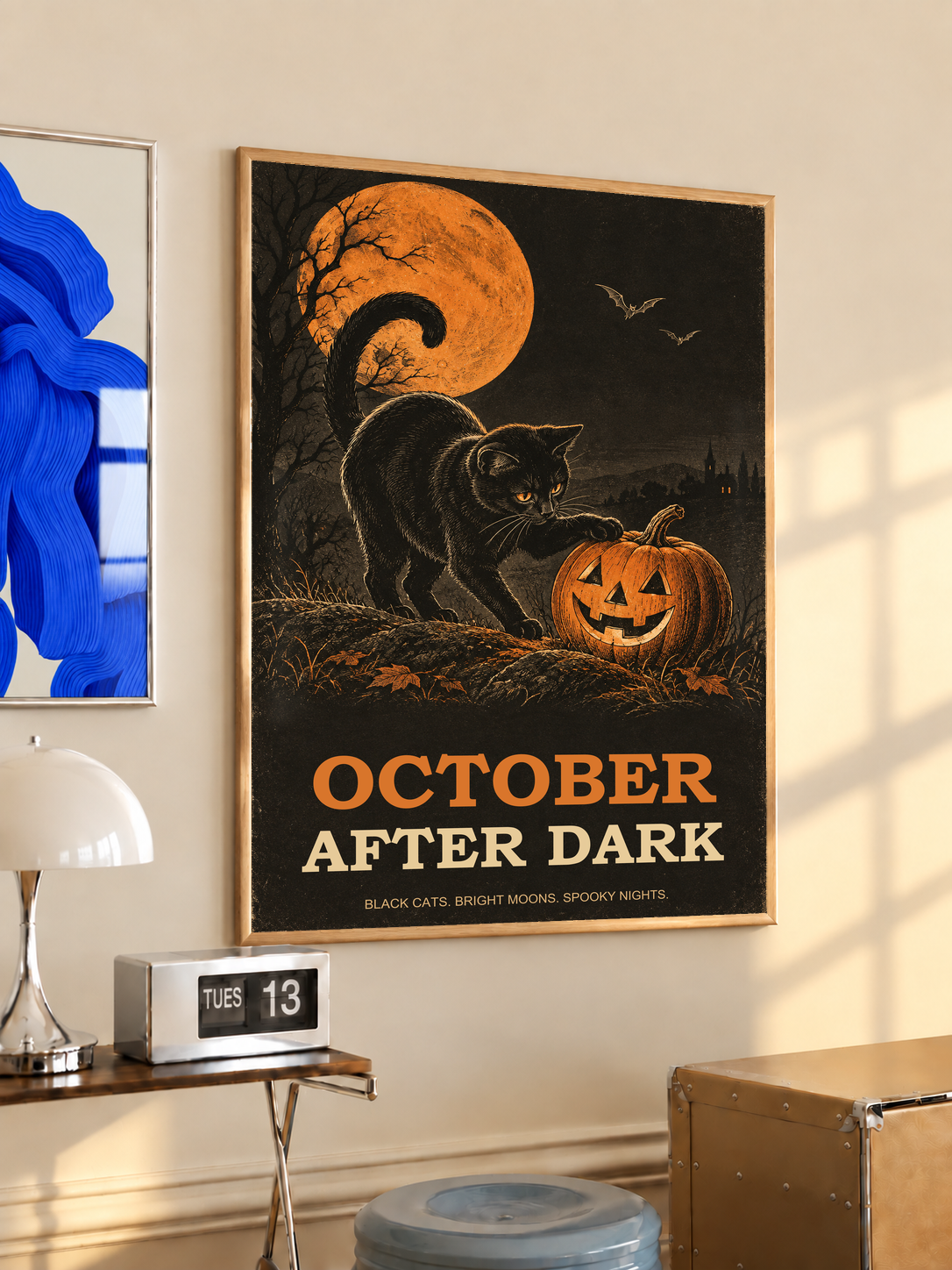 Framed Halloween poster of black cat beside jack-o'-lantern under orange moon with bats.