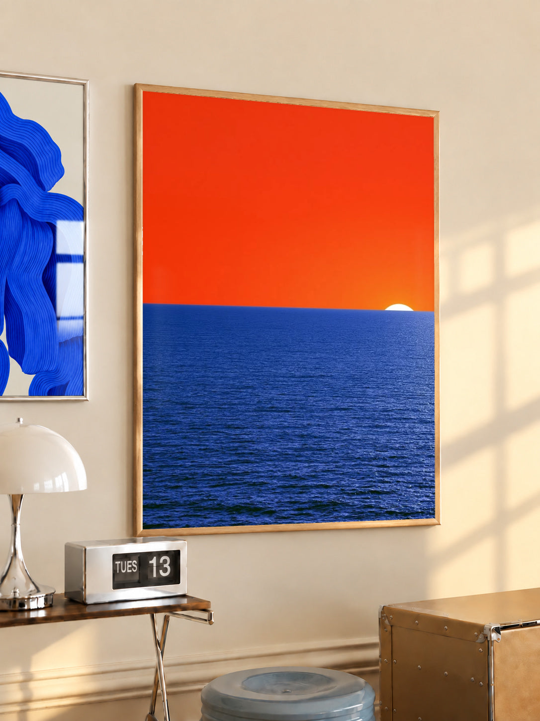 Coastal sunset wall art poster with orange sky, blue ocean, and a small white sun