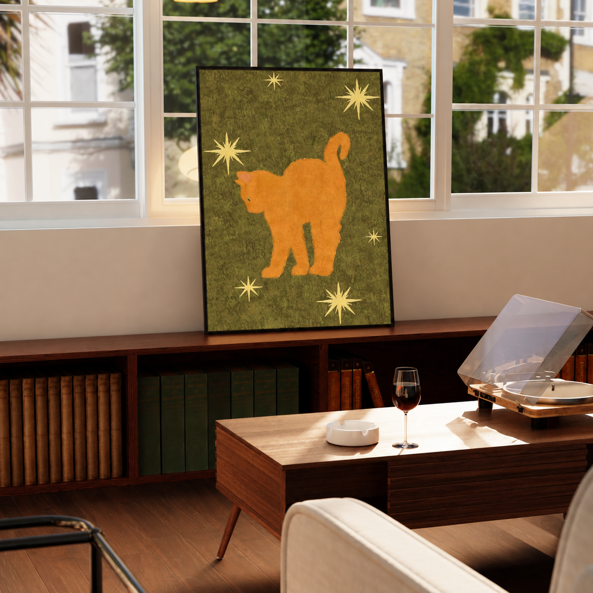 Orange cat art print with star details on olive green, in a black frame