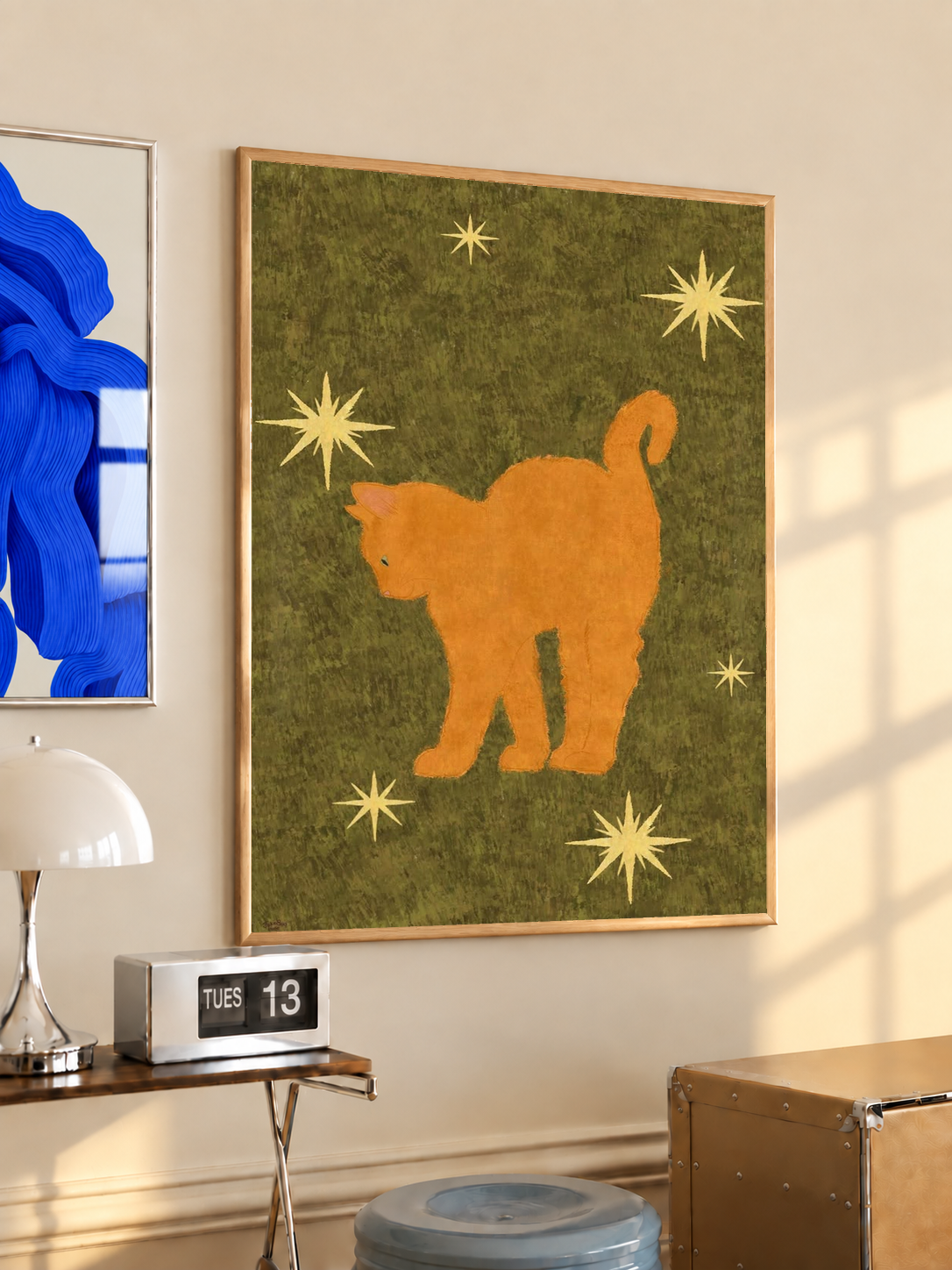 Orange cat art print with star accents on olive green background, in a wood frame