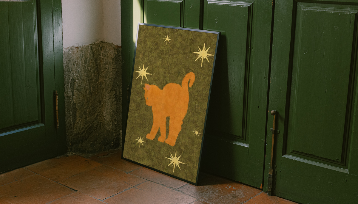 Orange cat and stars art print on olive green background, in a black frame