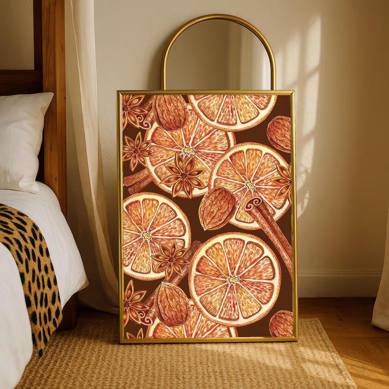 Gold-framed art print featuring orange slices, cinnamon, and star anise