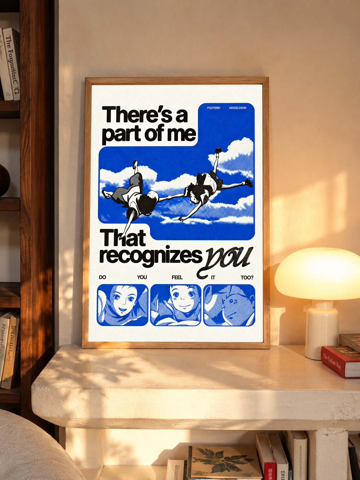 Two anime figures against blue sky with character portraits and a romantic recognition quote in an oak frame above a pale wooden sideboard beside a glowing lamp