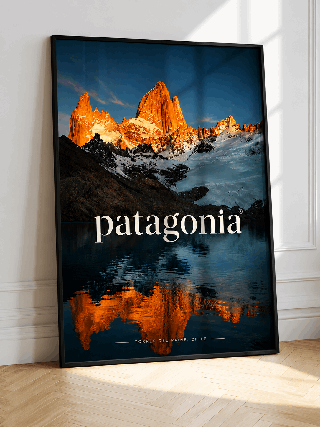 Mountain wall art poster with black frame, orange peaks and blue lake, patagonia text