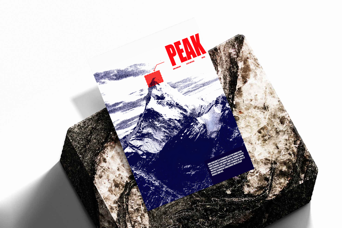 White and navy halftone Ama Dablam mountain with red PEAK lettering; unframed print on a stone display