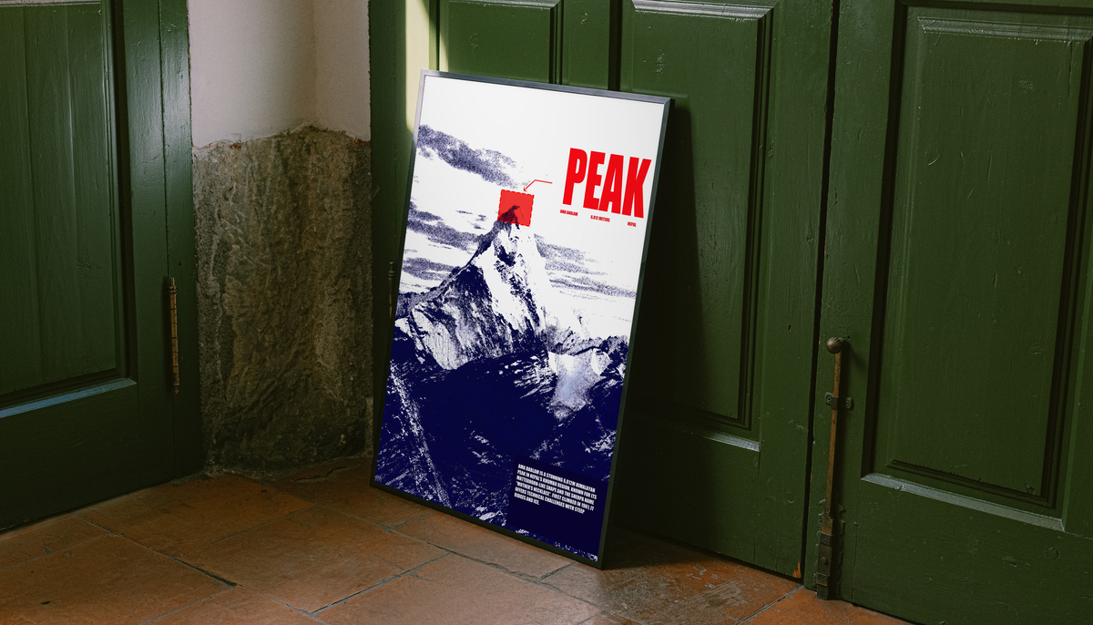 White and navy halftone Ama Dablam mountain with red PEAK lettering; unframed canvas styled by a green doorway