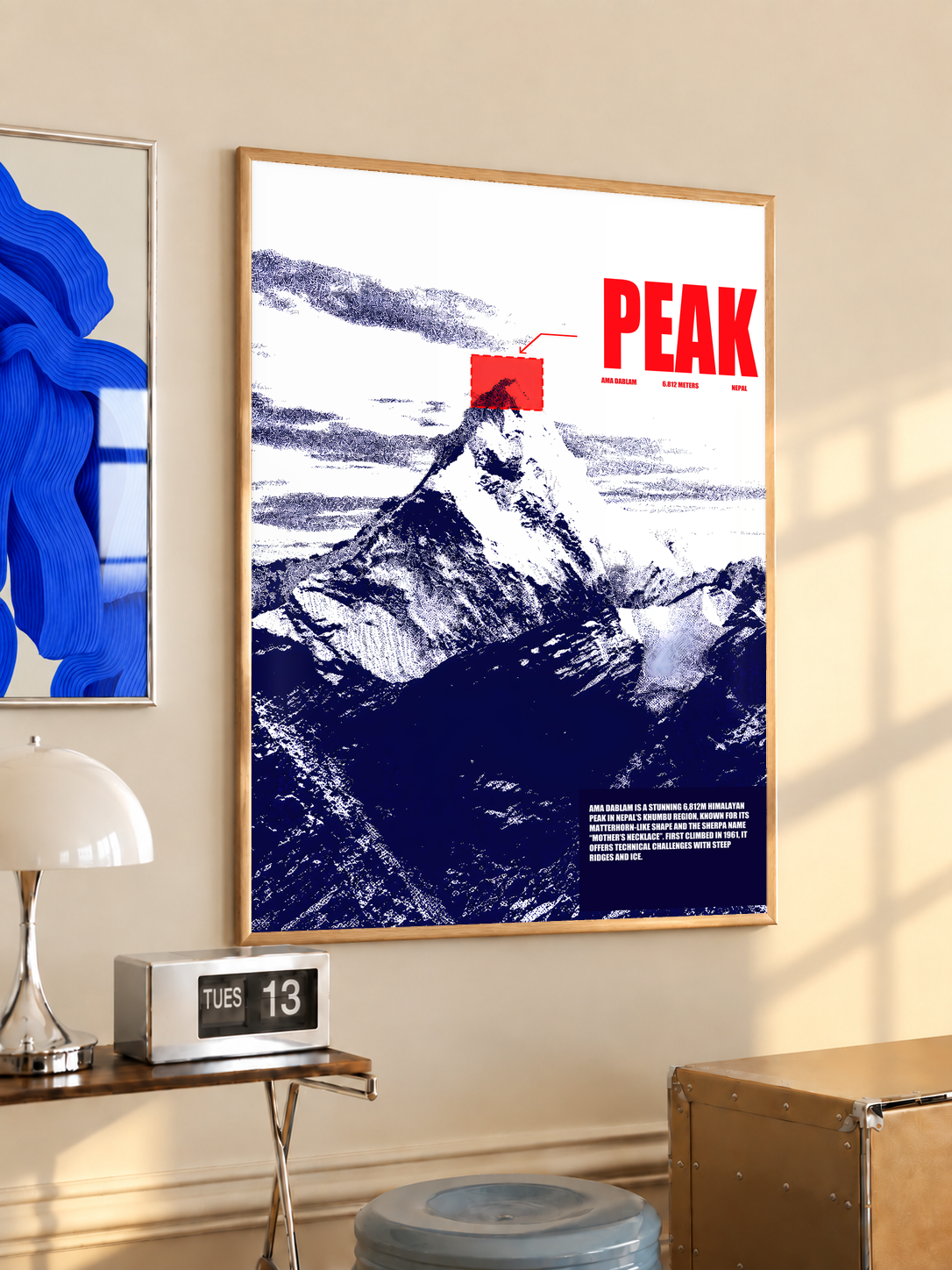 White and navy halftone Ama Dablam mountain with red PEAK lettering; oak framed print in a desk setting