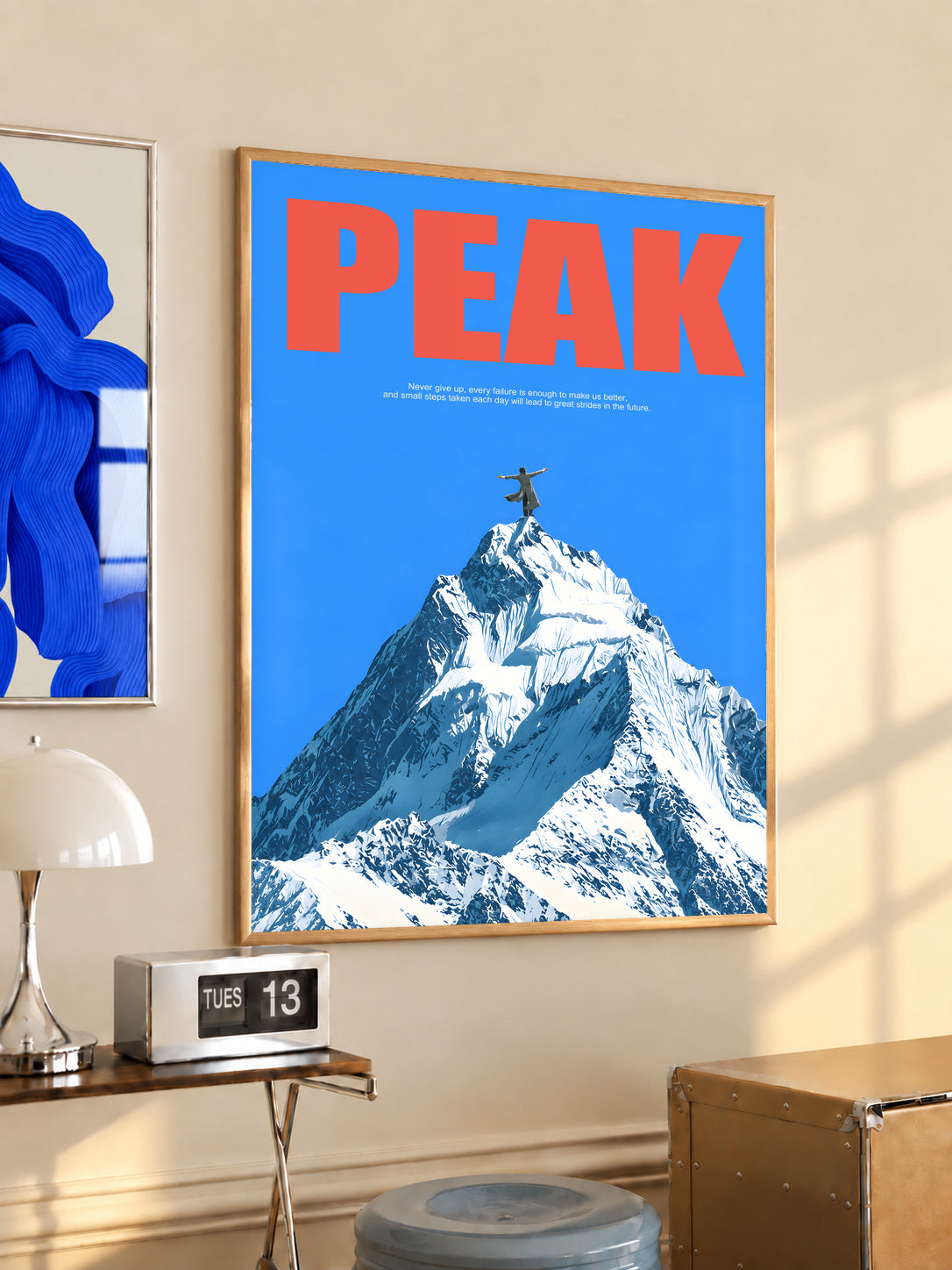 Peak Mountain Climber poster in a light wood frame, with red lettering and a snowy summit