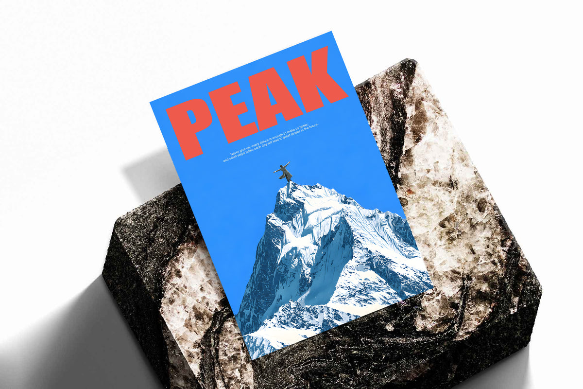 Peak Mountain Climber poster resting on a rock, with red lettering and a snow-covered peak