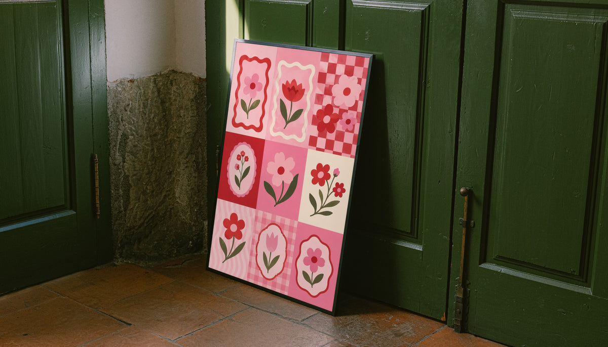 A pink and red patchwork grid of tulips, daisies, scalloped frames and checkerboard squares leaning on the floor against dark green wall panelling