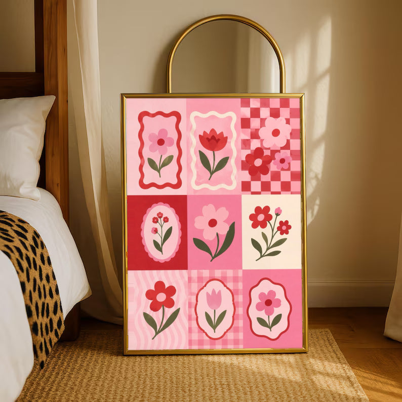 A pink and red patchwork grid of tulips, daisies, scalloped frames and checkerboard squares in a gold-tone styling frame leaning beside a bedroom mirror