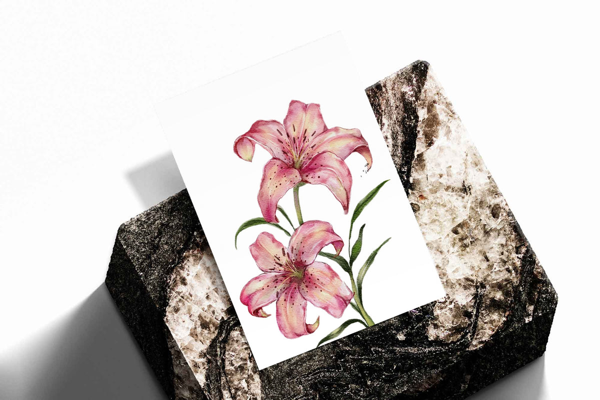 Two pink lilies with speckled petals and green leaves against white as an unframed print standing on a stone plinth against white