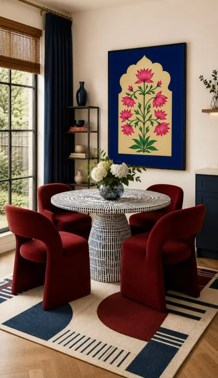 Pink lotus-like flowers and green stems within a scalloped gold arch on navy blue in a black frame on the wall of a dining nook with red chairs