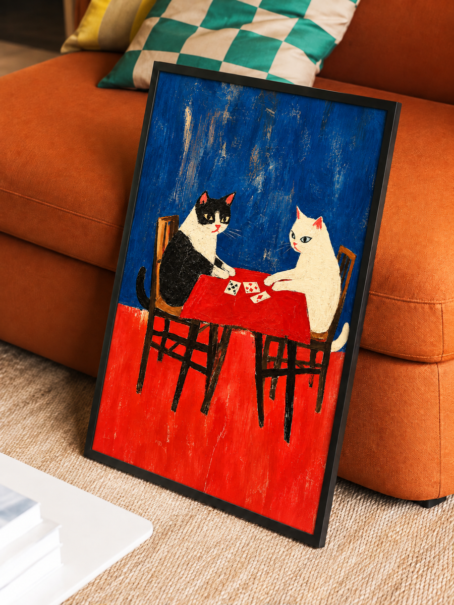 Black-framed folk art wall art: black and cream cats playing cards at red table