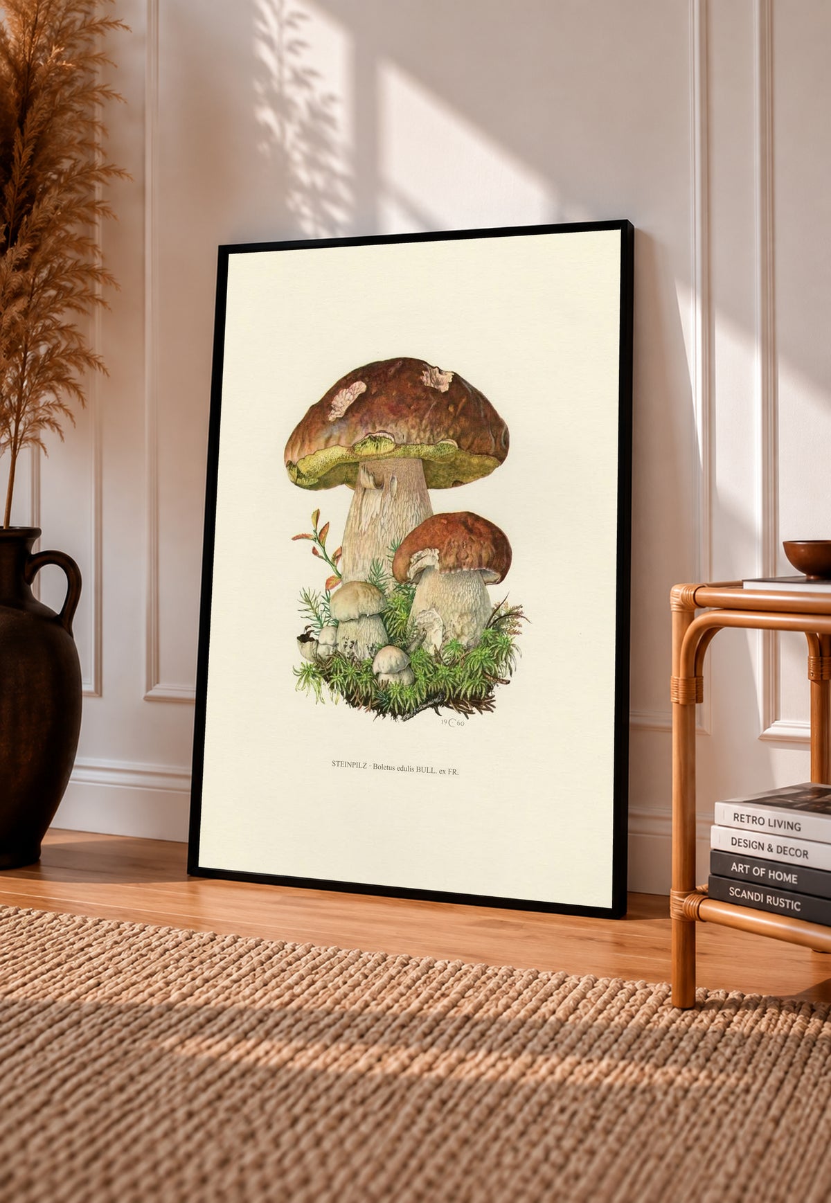 Brown porcini mushrooms with moss and a printed Steinpilz Boletus edulis caption in a black frame leaning on a sunlit wooden floor beside books and a rattan seat