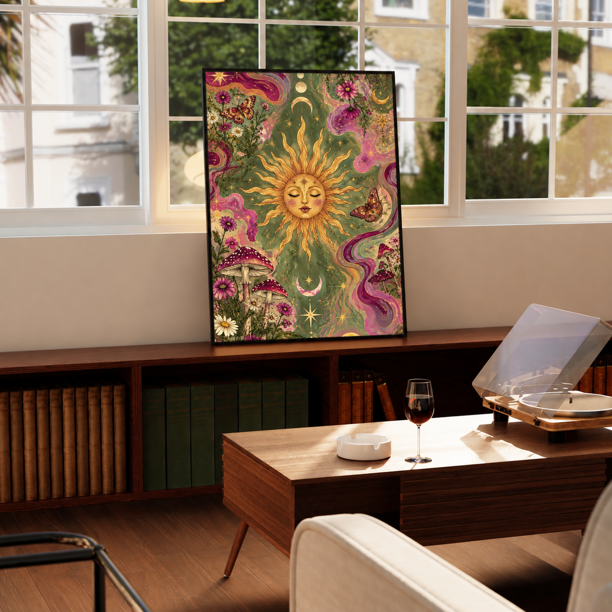 Celestial sun face, flowers and mushrooms in a black frame on a windowsill above a green radiator, with a turntable nearby