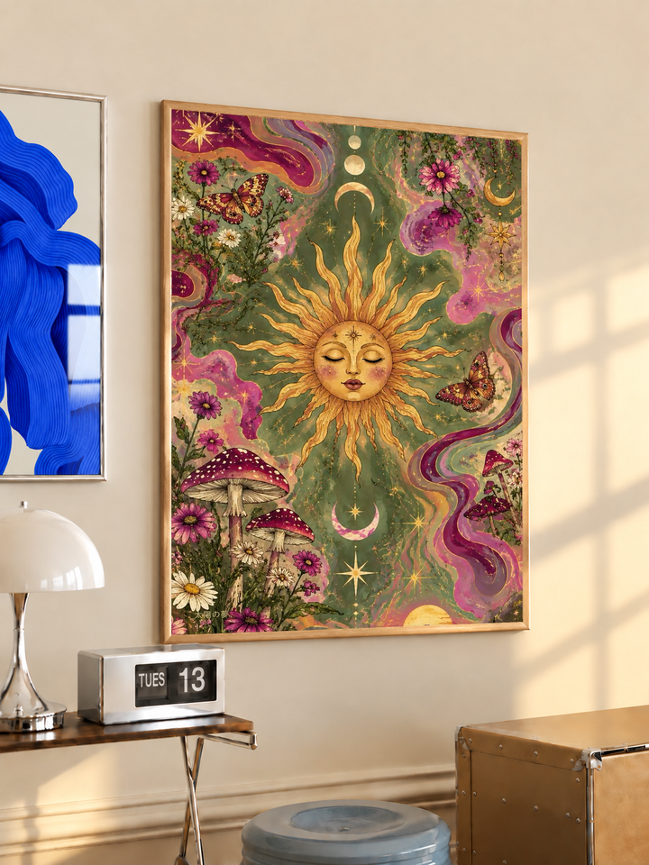 Celestial sun face, flowers and mushrooms in an oak frame on a warm cream wall above a small table and dome lamp