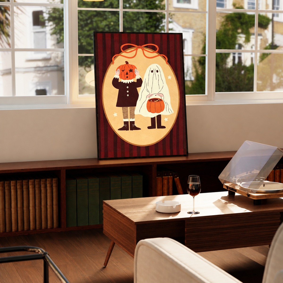 Black-framed Halloween poster showing pumpkin-head character and ghost with orange bow details