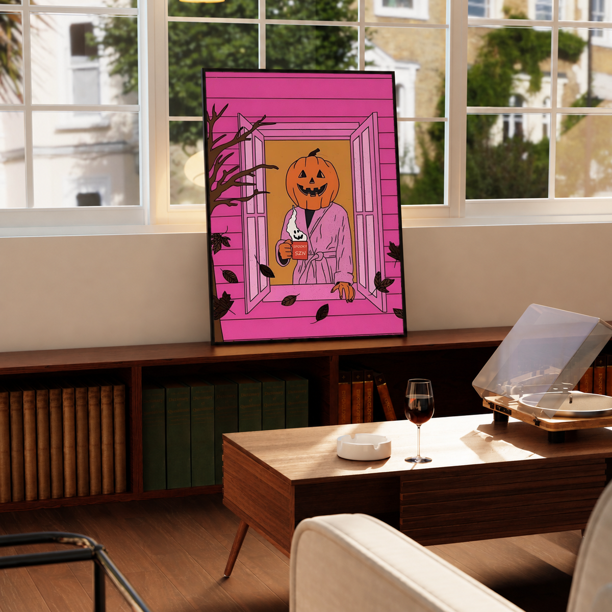 Framed Halloween poster on tabletop, jack-o'-lantern bathrobe character in pink doorway scene