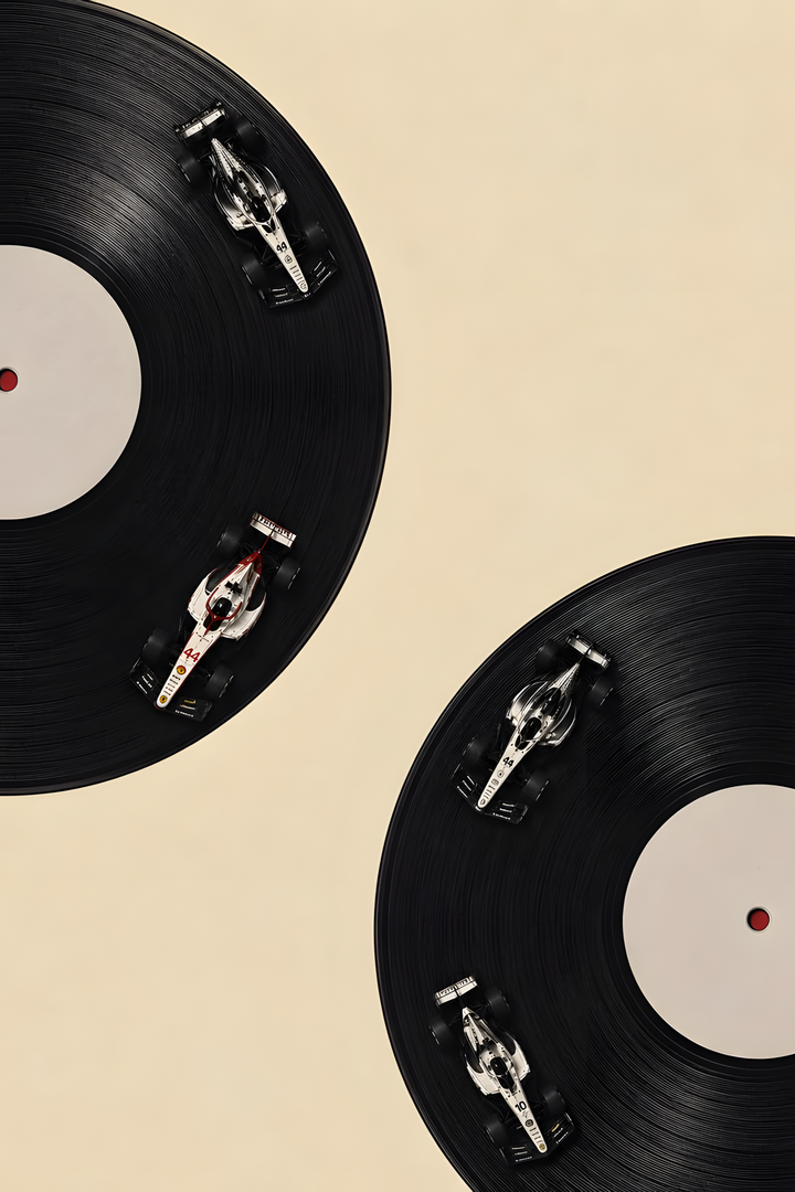 Four miniature race cars on the grooves of two black vinyl records against a cream background