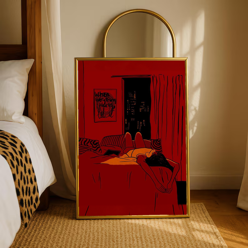 Red framed wall art print showing reclining woman lying on bed with dark city window