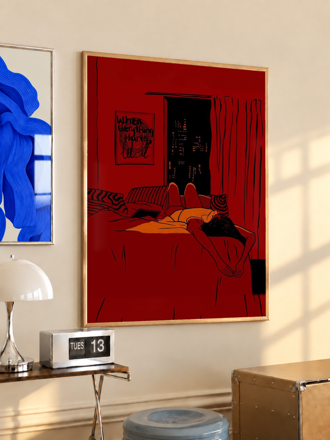 Red framed wall art print featuring reclining woman in bed with dark city skyline