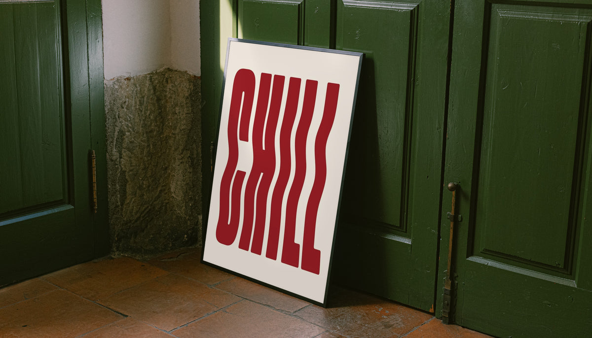 The word CHILL in tall wavy red lettering on a cream background leaning on the floor against dark green wall panelling