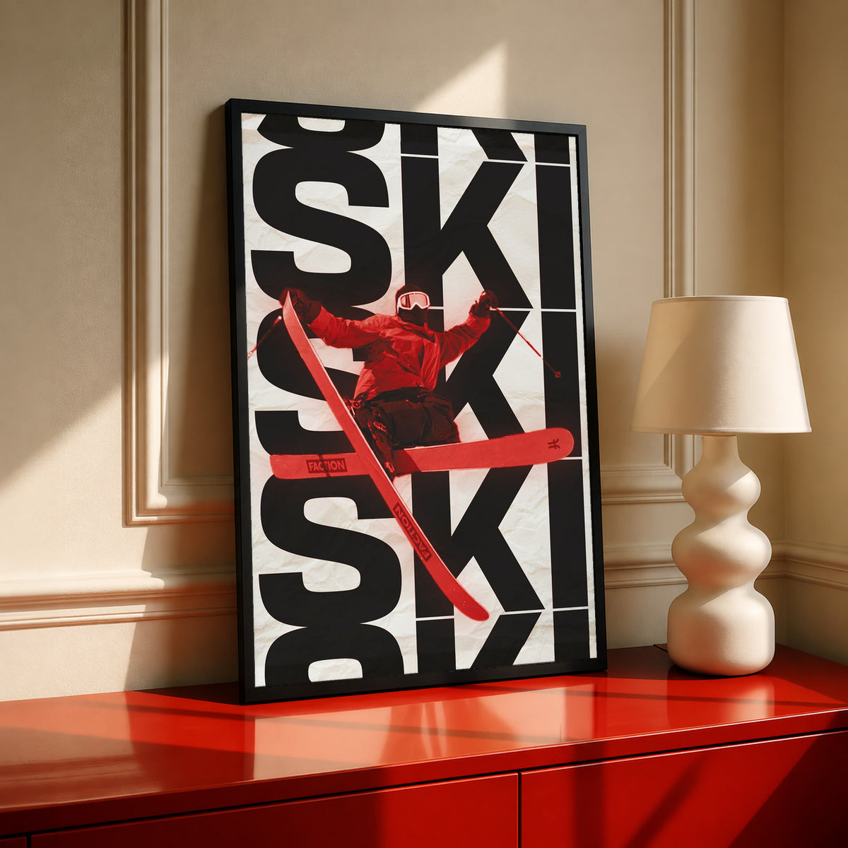 Framed ski poster featuring stacked black SKI letters and a red skier mid-ski