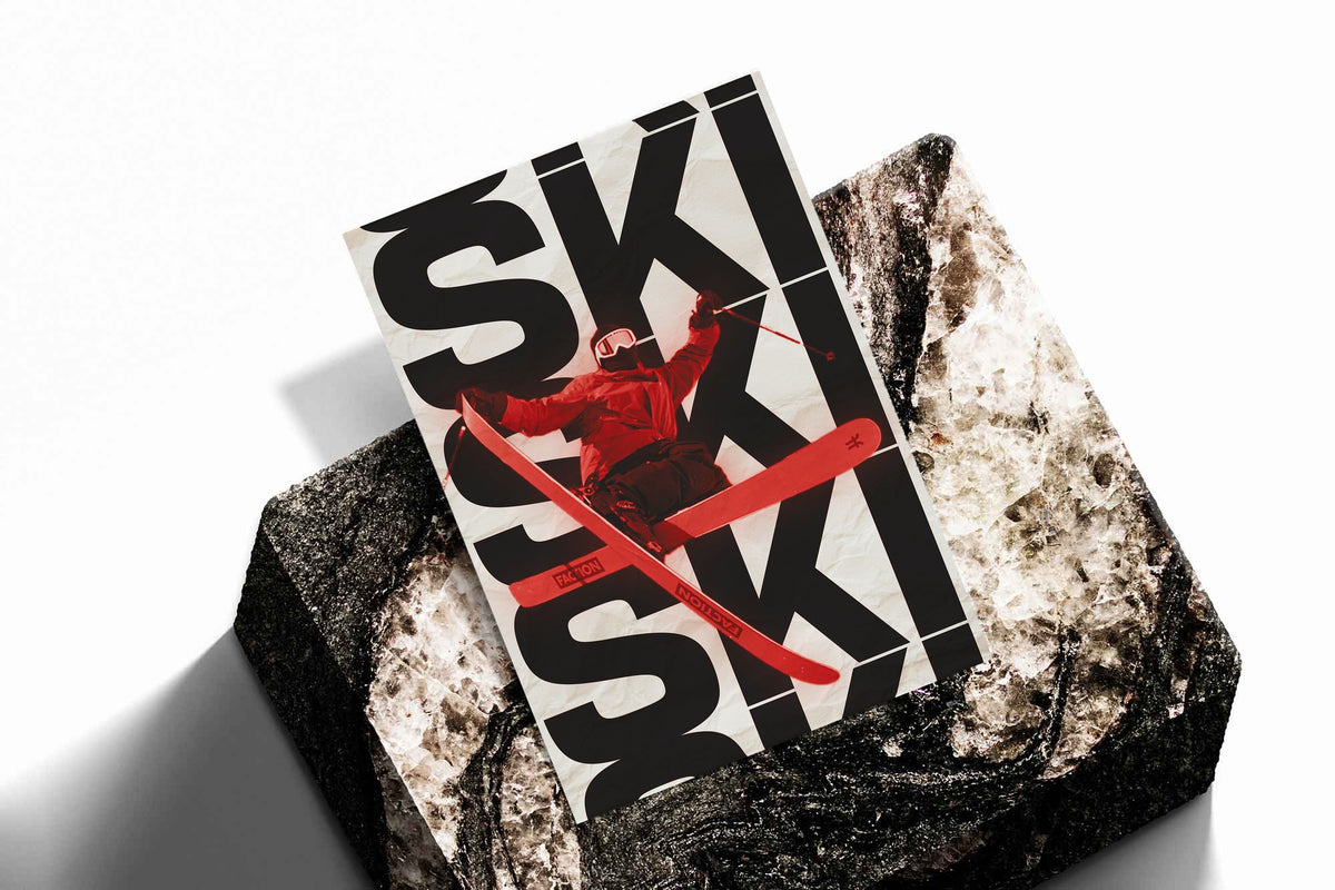 Unrolled ski poster showing bold black SKI letters and red skier on white background