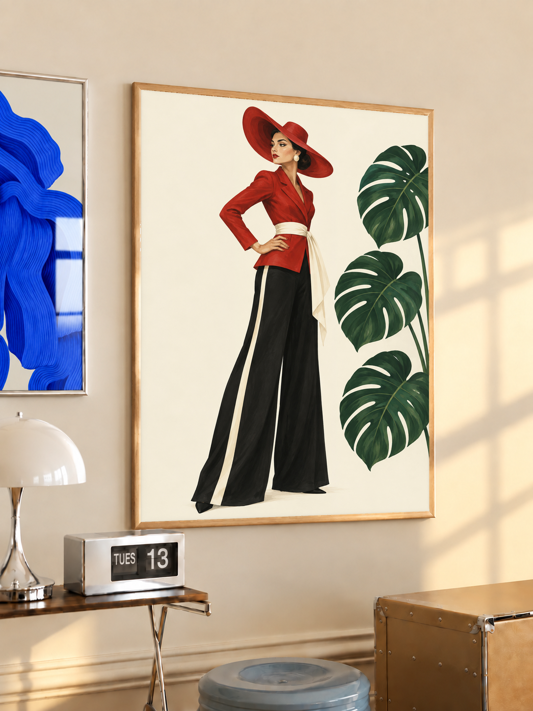 Wood-framed poster of woman in red hat and black wide-leg trousers with monstera leaves