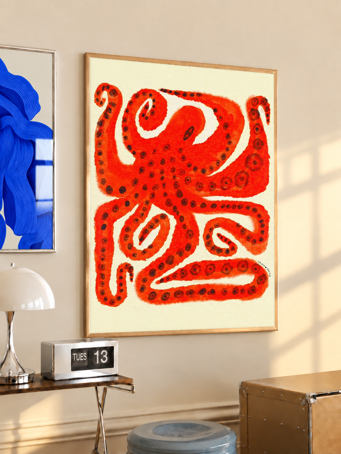 Gold-framed octopus art print with red curling tentacles on cream background