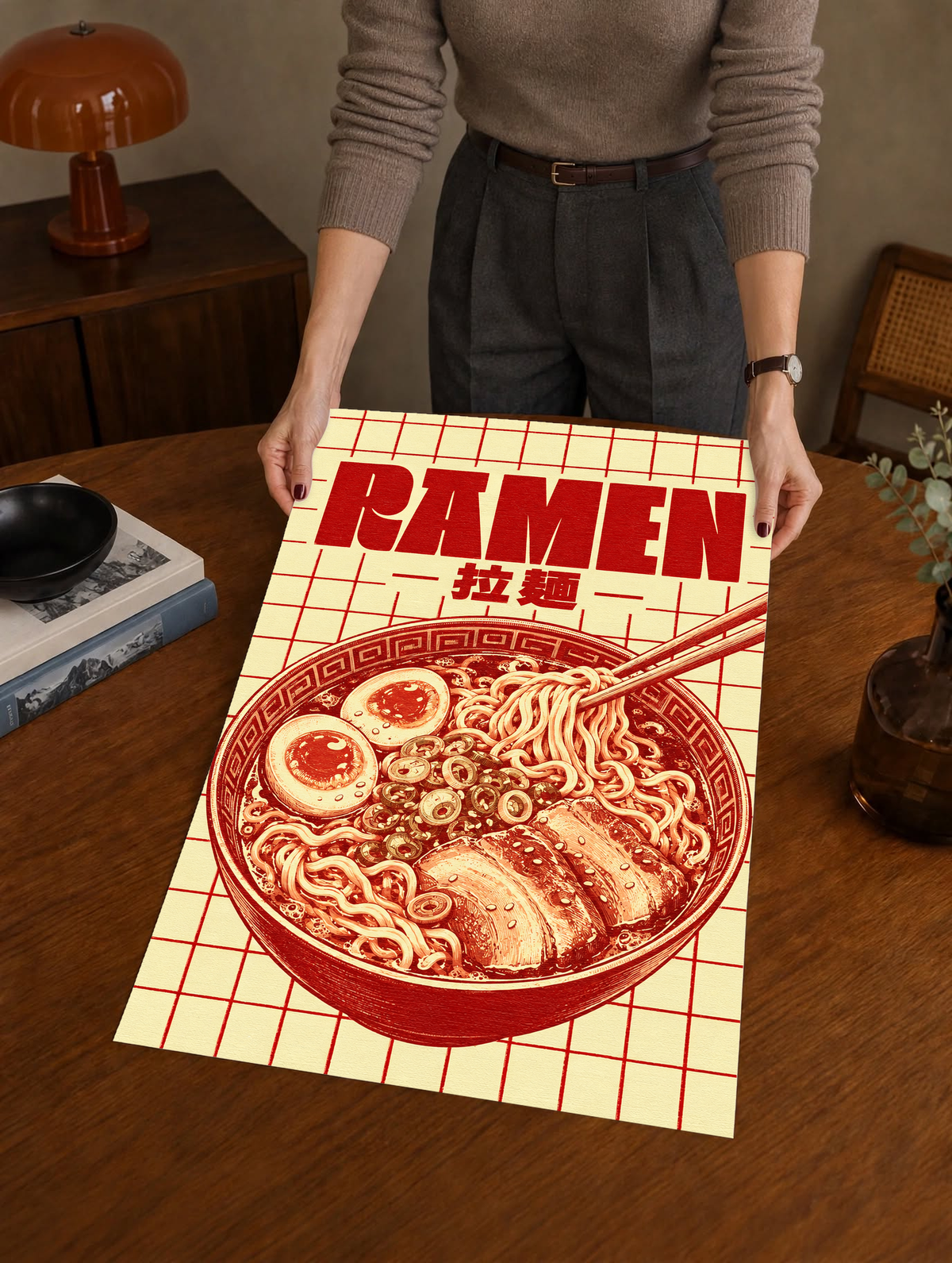 Framed ramen grid poster held upright, showing red noodle bowl art, chopsticks, and “RAMEN” text.