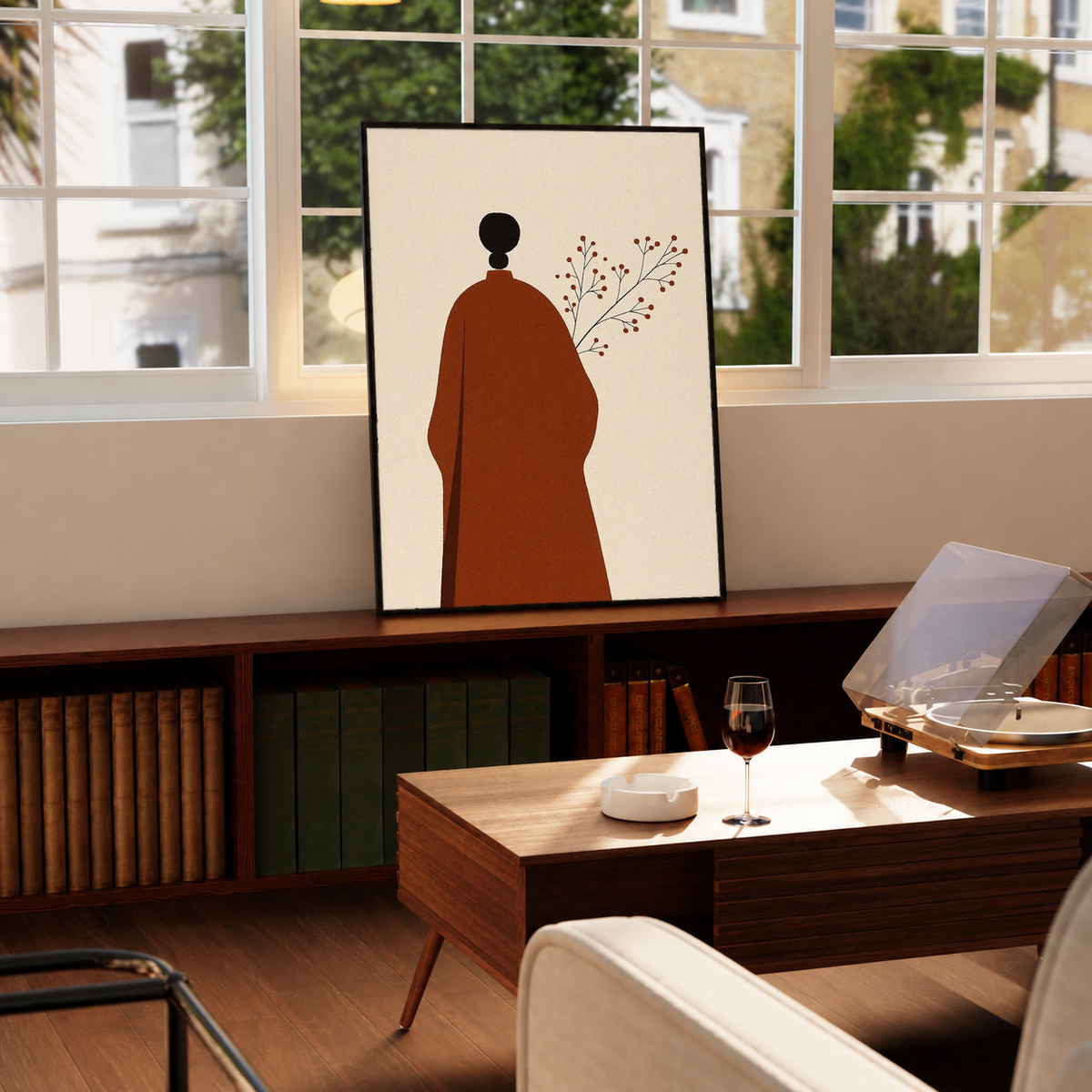 Cream art print with red robed figure silhouette, black head, and delicate branch in black frame