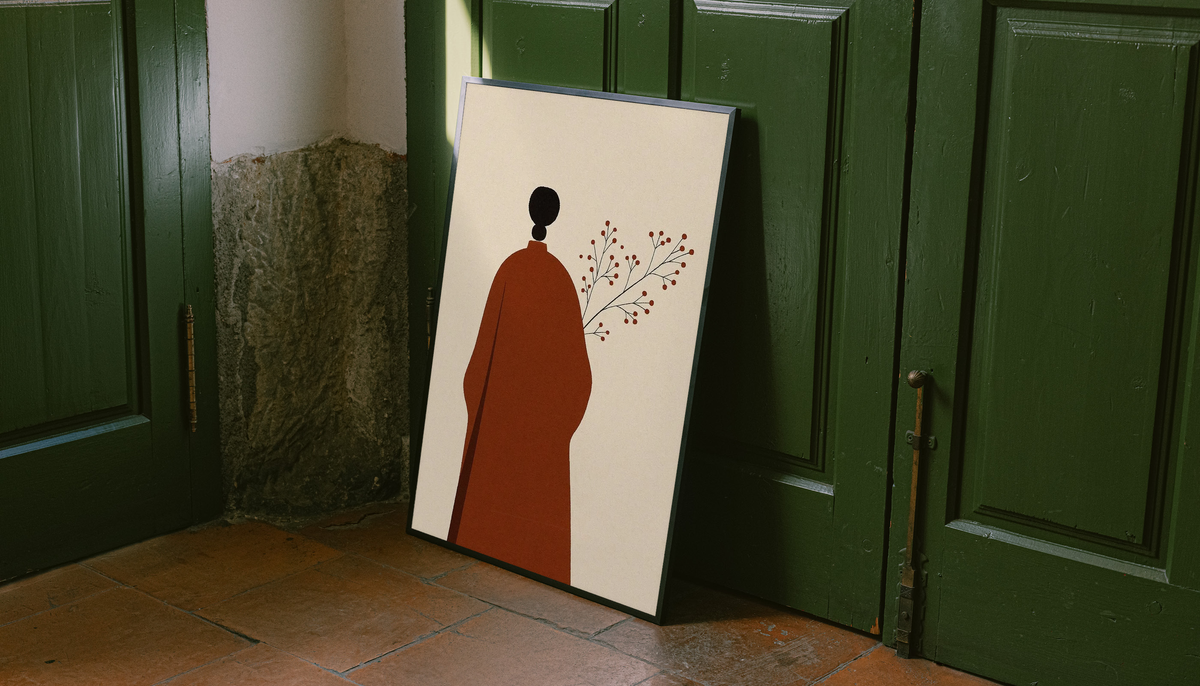 Cream art print with red robed figure silhouette, black head, and delicate branch in light frame