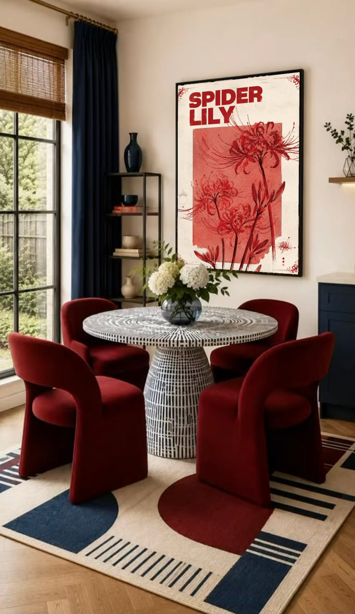 Red spider lily flowers and the words SPIDER LILY in a vintage cream and red botanical design in a black frame on the wall of a dining nook with red chairs