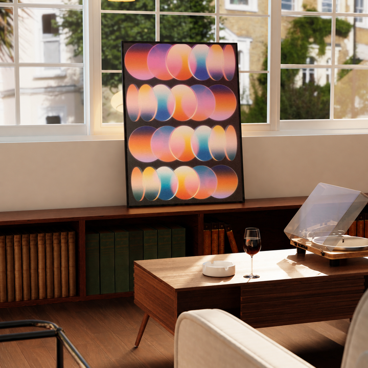 Retro Gradient Oval Poster in a black frame near a window and wooden table in a sunlit sitting room.