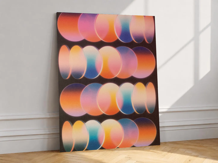 Canvas artwork depicting rows of overlapping graduated oval shapes, leaning against a white wall in angled sunlight.