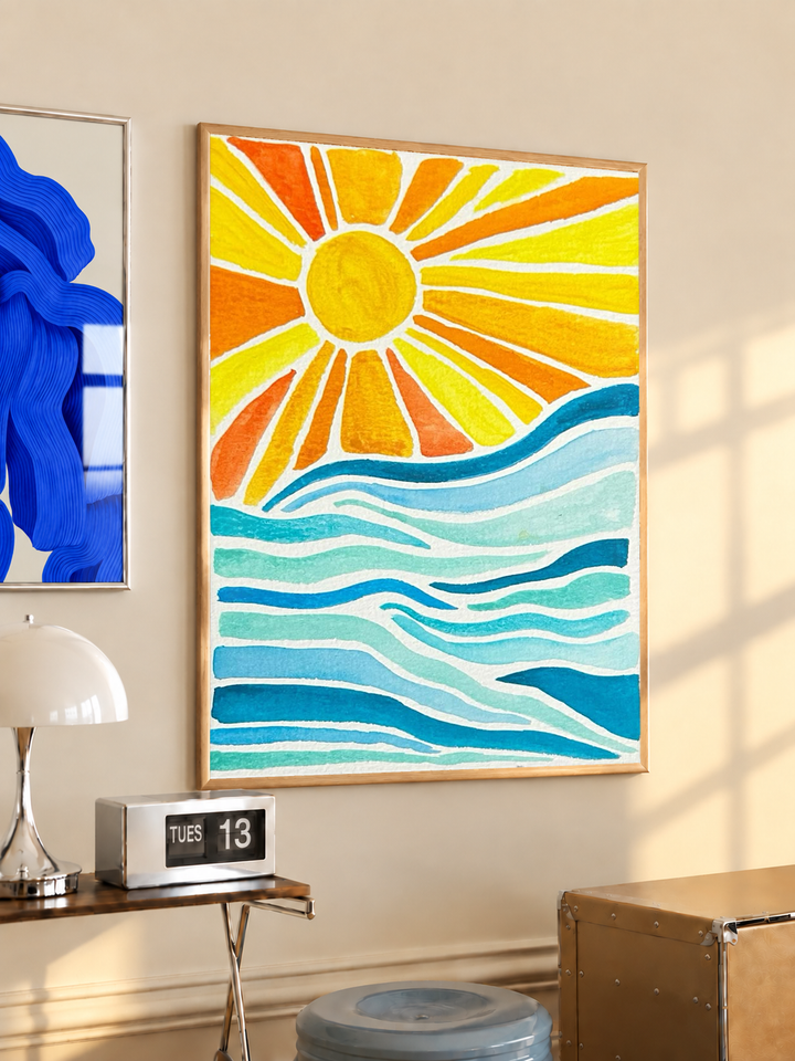 Sun rays over ocean waves in an oak frame on a warm cream wall above a small table and dome lamp