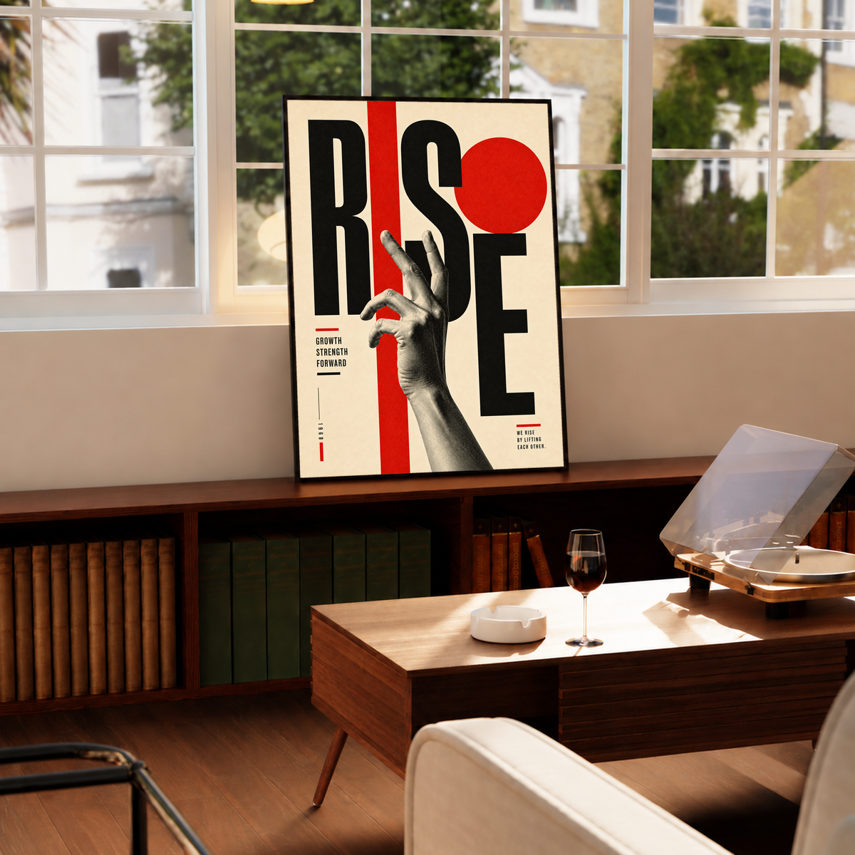 A reaching monochrome hand across oversized Rise lettering and red geometric shapes in a black frame by a bright window above a record player