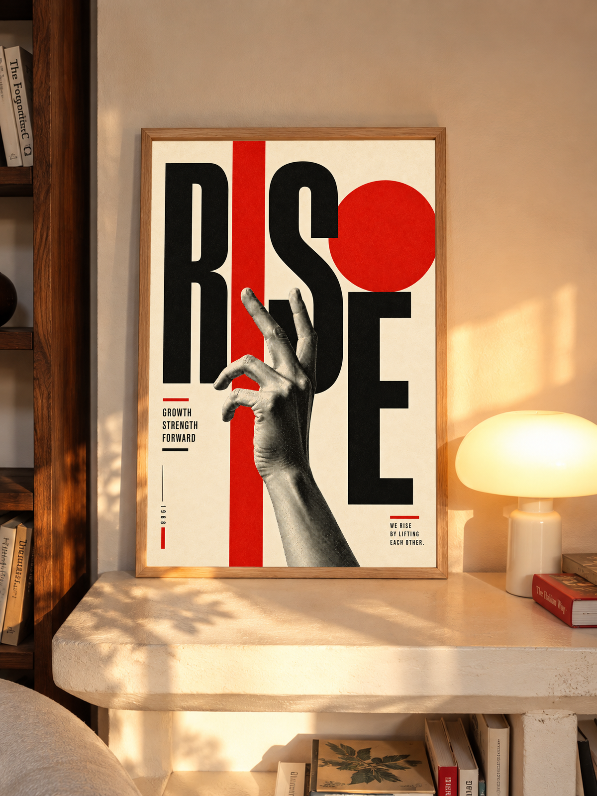 Framed typography poster leaning on table: black letters, red circle, and hand illustration.